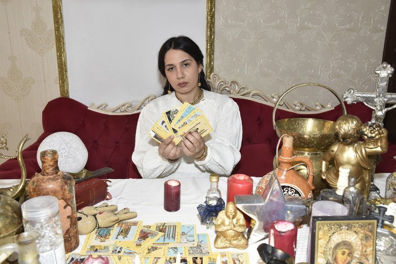 Carmen Rosca lucrând cu obiecte de cult sfințite la masa rituală