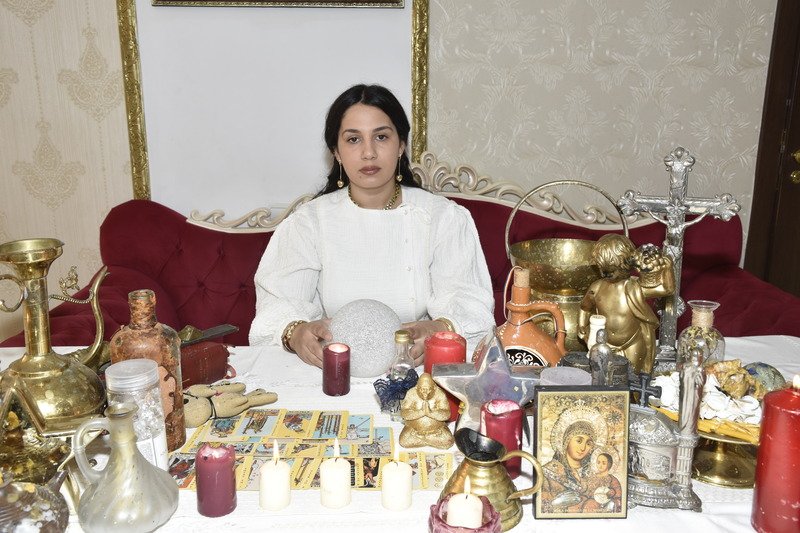 Carmen Rosca la masa rituală, pregătind un ritual de magie albă
